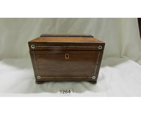 A 19th century mahogany tea caddy inlaid with mother of pearl.