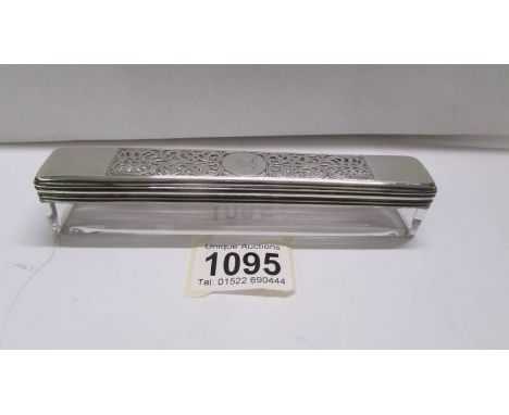 A glass trinket box with silver lid.