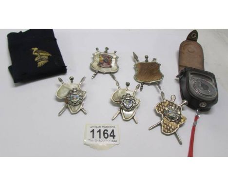 Five miniature African shields and a Sekonic light meter.