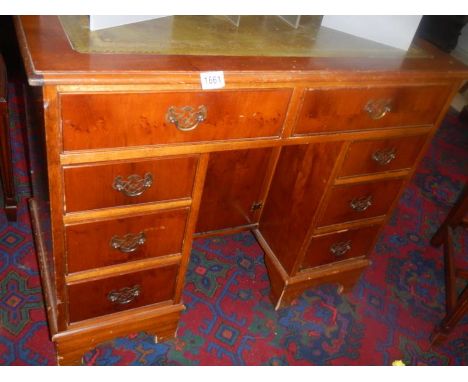 A light mahogany knee hole writing desk with centre cupboard and green leather top. COLLECT ONLY.