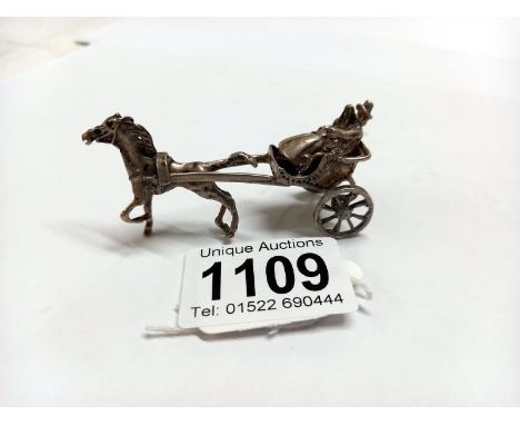 A miniature silver horse with carriage.