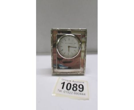 A silver Ari D Norman travel clock.