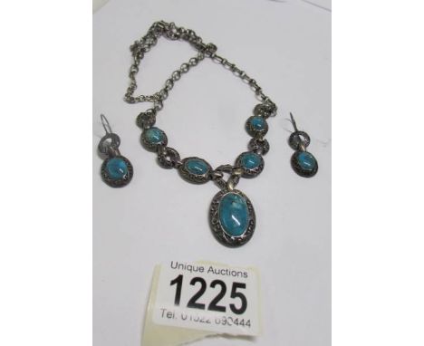 A silver stone set necklace with matching earrings.