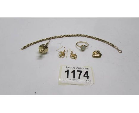 A gold bracelet, gold earrings with a cross design, a gold ring and a gold pendant.
