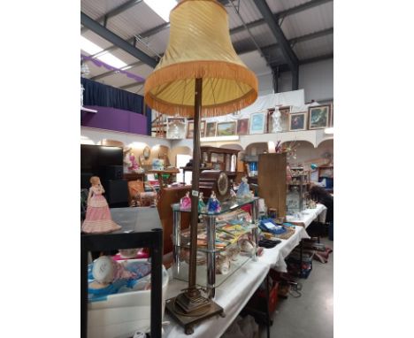 A brass effect standard lamp and shade