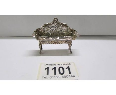 A small silver doll house sofa.