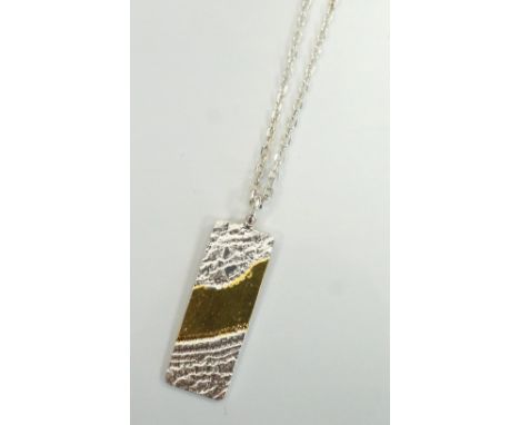 RECTANGLE LACE PENDANT BY MARION KANEin Sterling silver and 23 1/2 carat gold foil, with silver chain.Note: Marion Kane is an