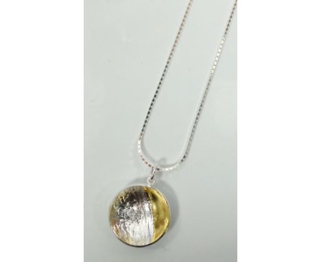 CIRCLE LACE PENDANT BY MARION KANEin Sterling silver and 23 1/2 carat gold foil, with silver chain.Note: Marion Kane is an aw