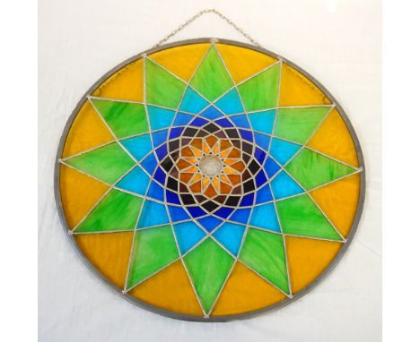 STAINED GLASS PANEL BY LEONA STEWARTthe stained glass panel of circular form with a geometric sunburst pattern, 53cm diameter