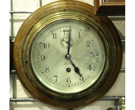 Bakers of Kensington brass clock mounted on an oak base, D: 19 cm. not working at lotting. P&amp;P Group 2 (£18+VAT for the f