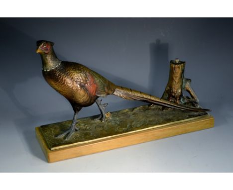 An Art Deco cold painted table lighter, cast as a pheasant beside a tree stump, wooden base, 31.5cm long, c.1935