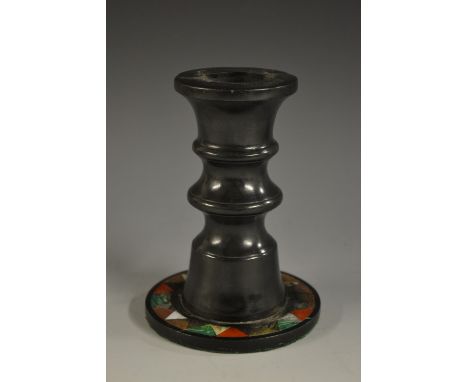 A black marble and pietra dura candlestick, bobbin turned column, slightly everted rim, circular base inlaid with a 'dogtooth