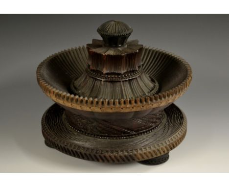 A substantial Anglo-Indian engine-turned lignum vitae inkstand, lift-off cover with domed finial, bun feet, 24cm diam, c.1880