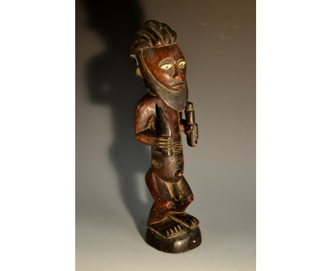 Tribal Art - a Uraba figure, of a bearded man, he stands holding implements, white pigment to eyes, the scarified markings to