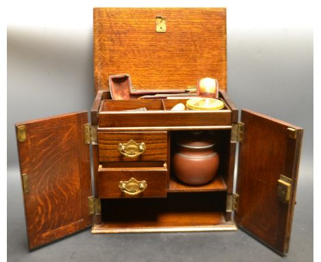 A oak smokers cabinet, engraved with flowers, lift out tray; smoking pipe etc 