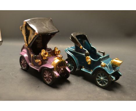 A Bretby model of a car, glazed in tones of purple and gilt; another, similar, glazed in tones of vibrant blue and gilt (2)