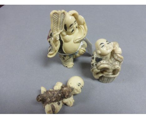 Three netsuke type figures to include man with fan, boy with dog and man with basket washing animal (?)
