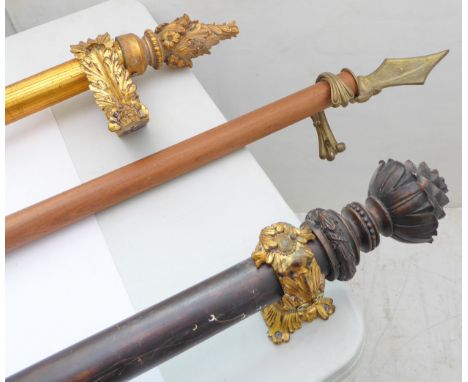 Three curtain poles; one long stained wood example as an arrow with head and feather flight, one gilded with acanthus support