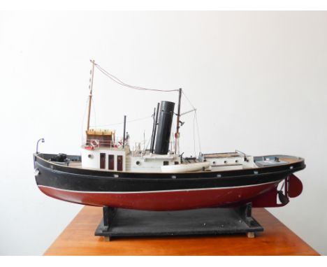 A custom-built model of a Thames Tug (108cm long x 28cm widest) resting upon a black painted custom-built stand