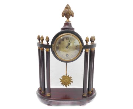 An early 20th century mahogany and brass-mounted mantle clock in classical style; the central finial cast and modelled as flo