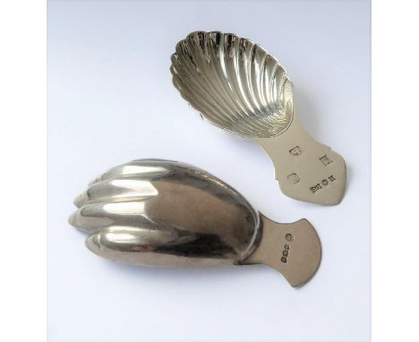 A silver caddy spoon in the shape of a hand, assayed Sheffield 1971 and a shell-shaped example assayed Birmingham 1957
