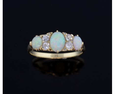 Edwardian opal and diamond carved hoop ring, set with three cabochon-cut opals with two old cut diamonds set in between, scro