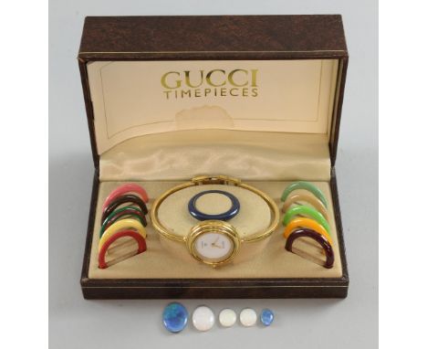 A  Gucci watch with interchangeable bands, cased, an opal doublet and three others 