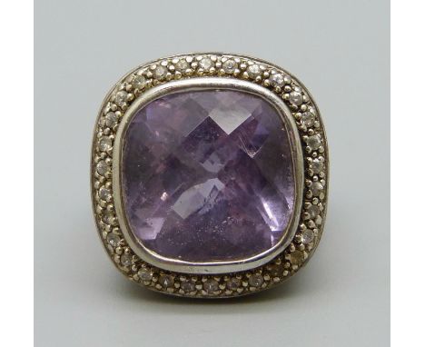 A large silver set ring with an amethyst coloured stone, N 