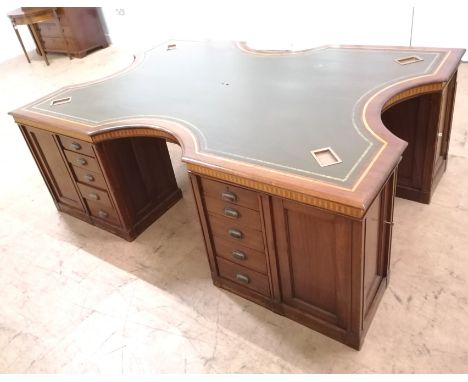 A 1920/30s mahogany and inlaid partners desk of large proportions, having a shaped top with inset green sciver and inserts fo