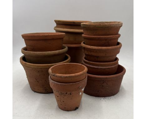 A vintage terracotta strawberry forcer along with an assortment of terracotta pots.