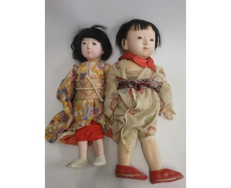 Two Japanese composition head dolls, with glass eyes, closed mouths, composition and cloth bodies, and traditional dress, 20 