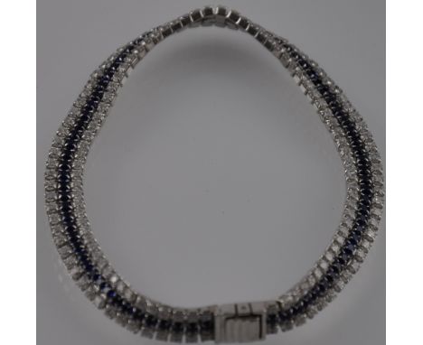 A silver, cubic zirconia and sapphire tennis bracelet