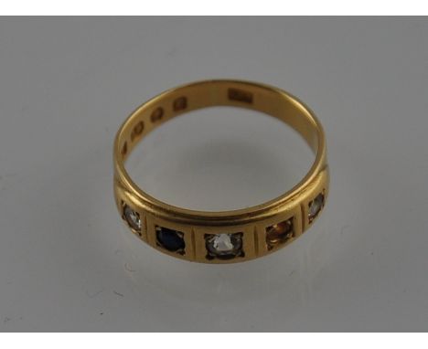 A sapphire and diamond ring, the four counter sunk stones in an 18ct yellow gold band, 3.8 grams (1 stone missing)