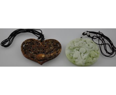 A Chinese carved jade disc pendant together with a carved and pierced soapstone heart-shaped pendant