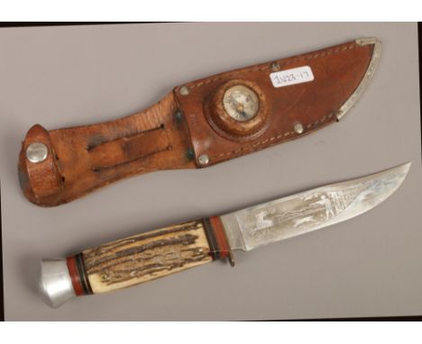 A horn handle hunting knife stamped Puma Solingen, hunting scene decoration to the blade in leather sheath with mounted compa