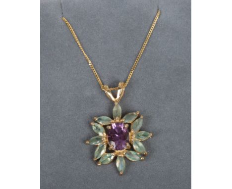 A 9ct gold pendant on chain set with an amethyst and emeralds.