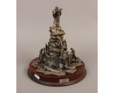 A cast metal myth and magic fantasy display entitled The Dragon Master raised on turned wood plinth.
