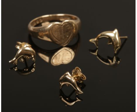 A 9ct gold heart shaped ring along with a pair of 9ct gold dolphin earrings and a similar yellow metal example.
