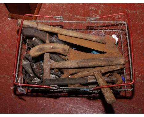 A basket of tools to include hatchet, hammer, spanner etc.