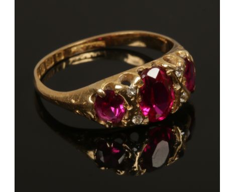 An Edwardian 18ct gold ring, set with three faceted red stone, boarded by diamonds, assayed Birmingham 1903, size M1/2.