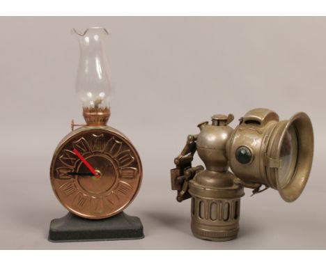 A vintage Miller carbide light along with a novelty oil lamp of clock form.