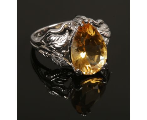 A 9ct white gold dress ring set with a large pear cut citrine on openwork foliate shoulders with certificate, size N 1/2.