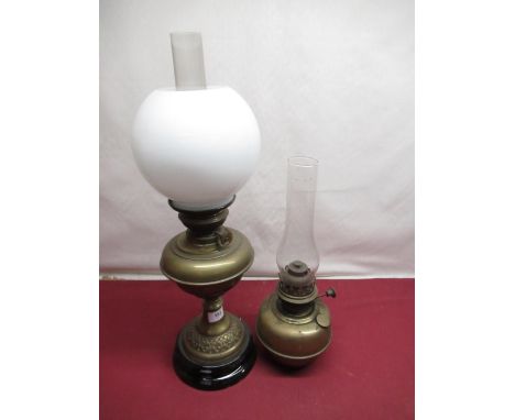 Brass oil lamp on black terracotta base with chimney and white globe shade, and a Veritas brass oil lamp 