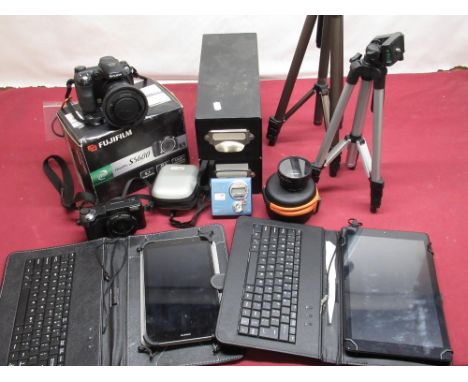 Collection of various photographic items, including a Fuji FinePix S5600 tripod, unnamed digital compact cameras, two tablets
