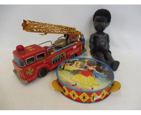 A Japanese tinplate Fire Dept. engine, a Chad Valley tambourine and a plastic black doll with voicebox.