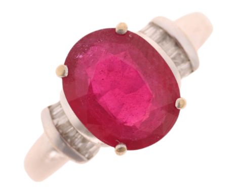 A modern 18ct white gold ruby and diamond dress ring, claw set with 2.7ct oval mixed-cut ruby flanked by baguette-cut diamond