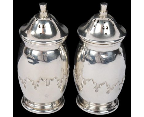A pair of George V silver pepperettes, Roberts & Dore Ltd, Birmingham 1935, ovoid form with relief embossed holly leaf decora