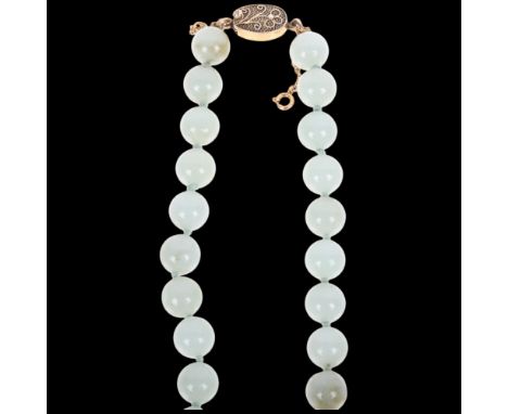 A Chinese single-strand jade bead necklace, with silver-gilt and floral clasp, 10.1mm beads, 50cm, 86.1g2 petals missing from
