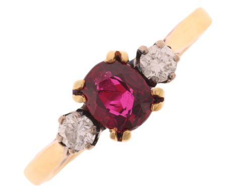 An 18ct gold three stone ruby and diamond ring, maker AJW, London 1980, set with 0.65ct oval mixed-cut ruby flanked by modern