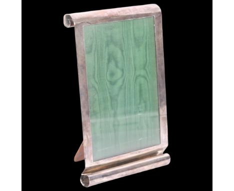 A George VI silver 'Scroll' photo frame, E Mander Ltd, Birmingham 1937, rectangular form with oak strut backing, overall 26.5
